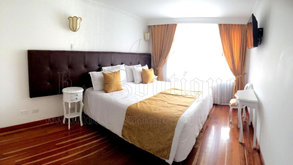 - une chambre avec un grand lit et une grande fenêtre dans l'établissement Hotel Boutique Feria Internacional, à Bogotá