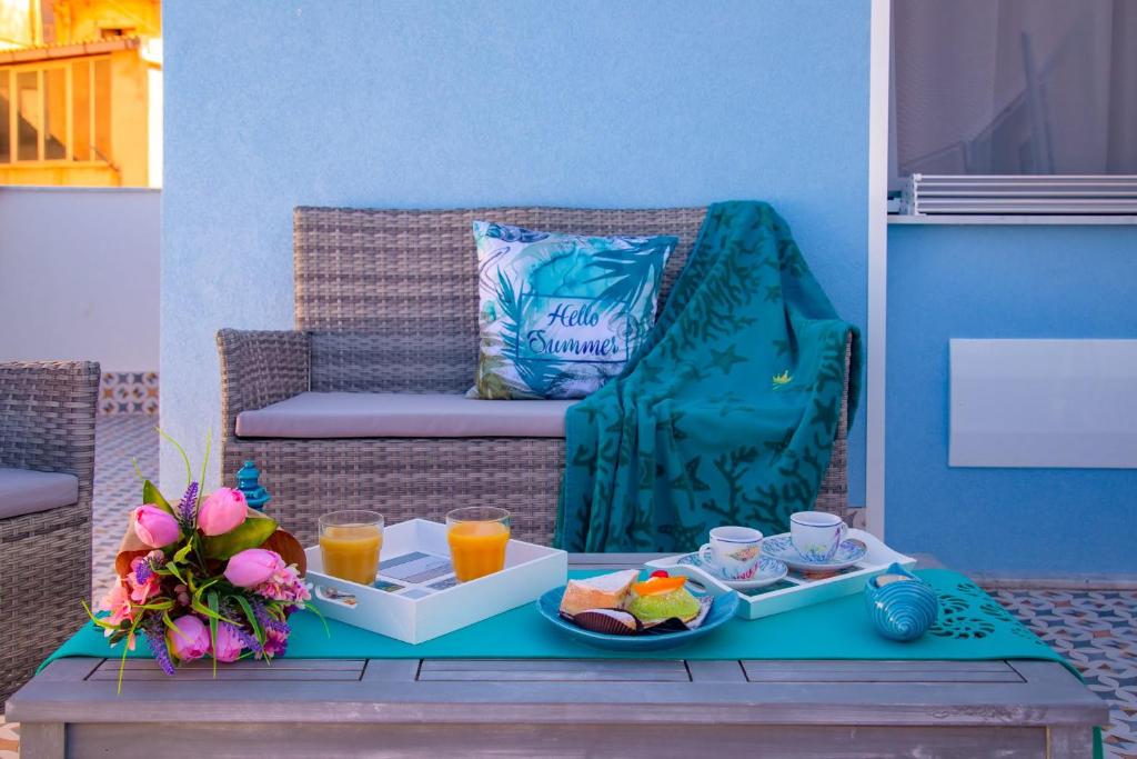 a table with a tray of food and drinks on a bench at Vittoria Luxury Rooms in Sciacca