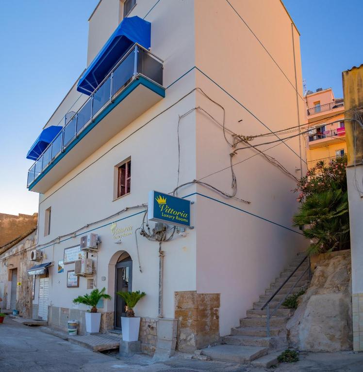 a building with a sign on the side of it at Vittoria Luxury Rooms in Sciacca