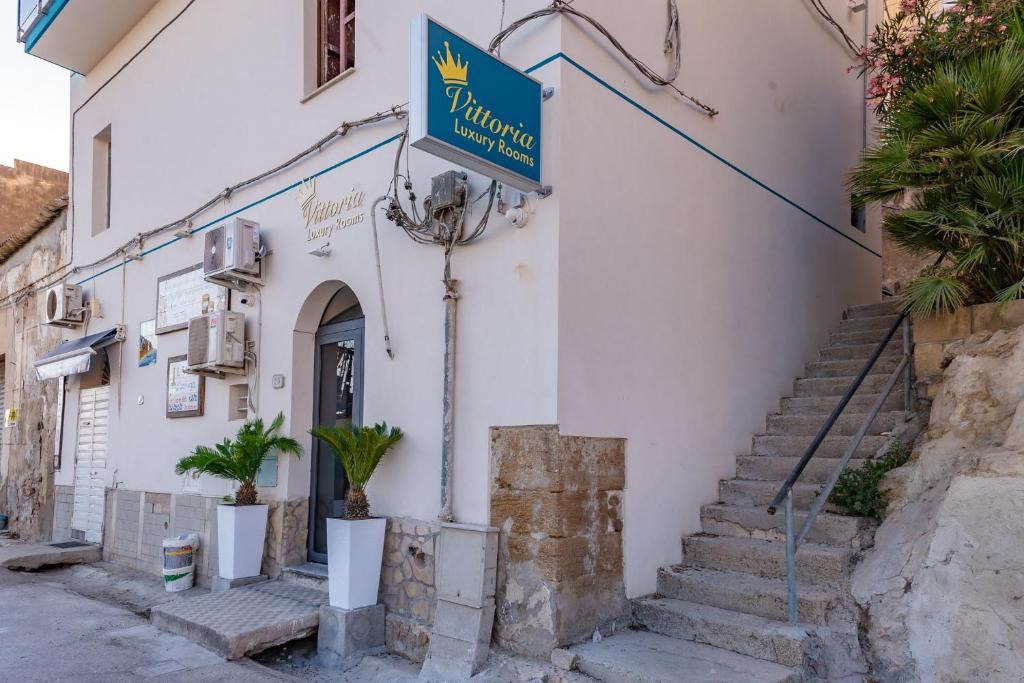 a building with a sign on the side of it at Vittoria Luxury Rooms in Sciacca