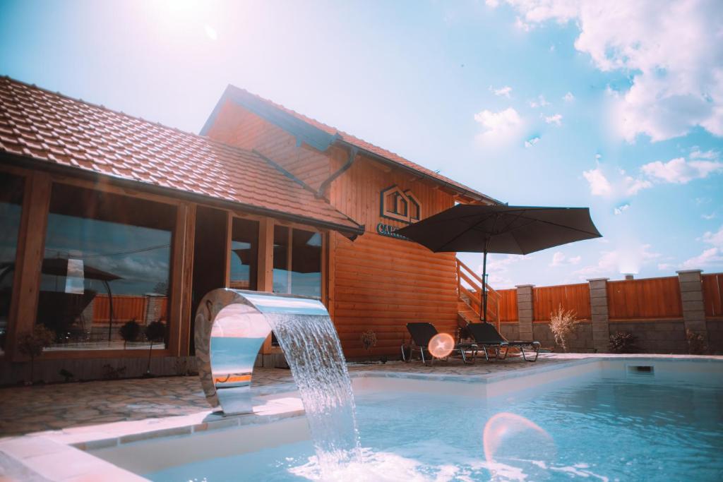 a swimming pool with a fountain in front of a house at Cartagena Villa & Spa in Brčko