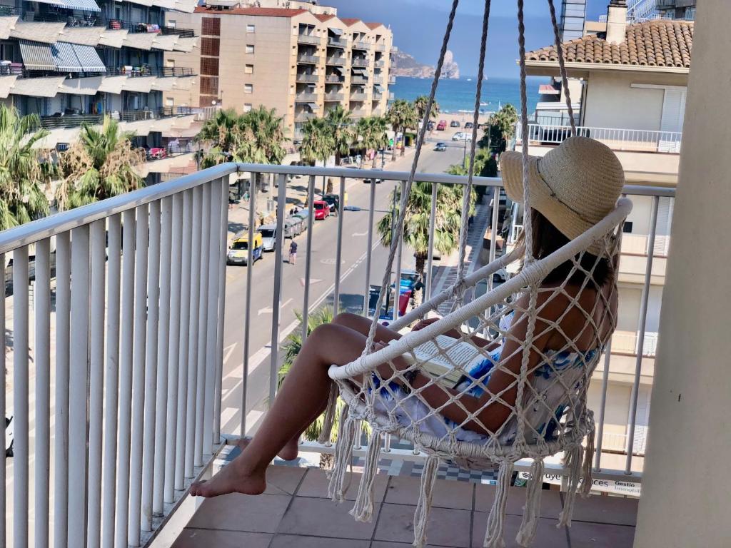 een vrouw in een stoel op een balkon bij Estartit Delta 4C in L'Estartit