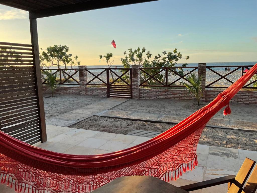een hangmat op een patio met uitzicht op de oceaan bij BEACH HOUSE - Suite 2 - NA PRAIA -BEACHFRONT in Barra Grande