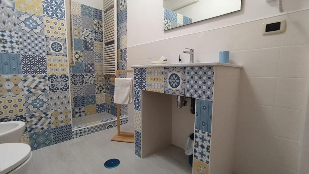 a bathroom with blue and white tiles on the wall at B&B Nonna Maria in Lizzano