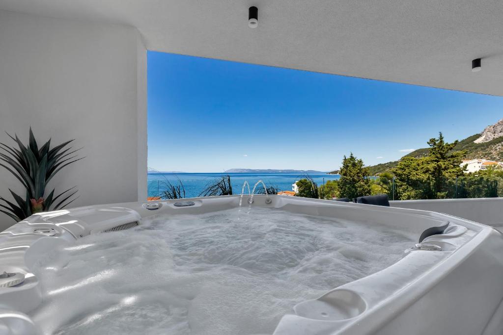 a white bath tub with a view of the ocean at Apartman Villa Soll in Drašnice