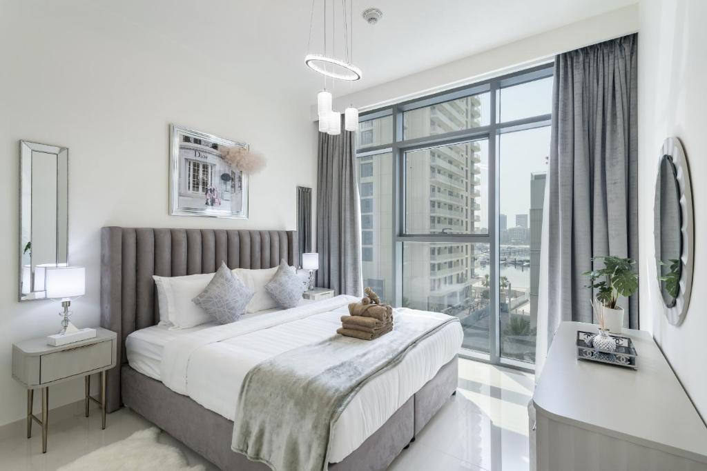 a bedroom with a large bed and a large window at Beach Vista Tower 1 - 1BR Apartment - Allsopp&Allsopp in Dubai
