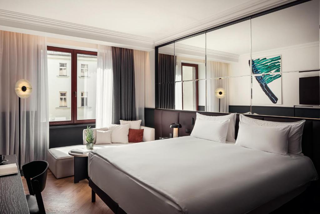a hotel room with a large bed and a large window at Alcron Hotel Prague in Prague