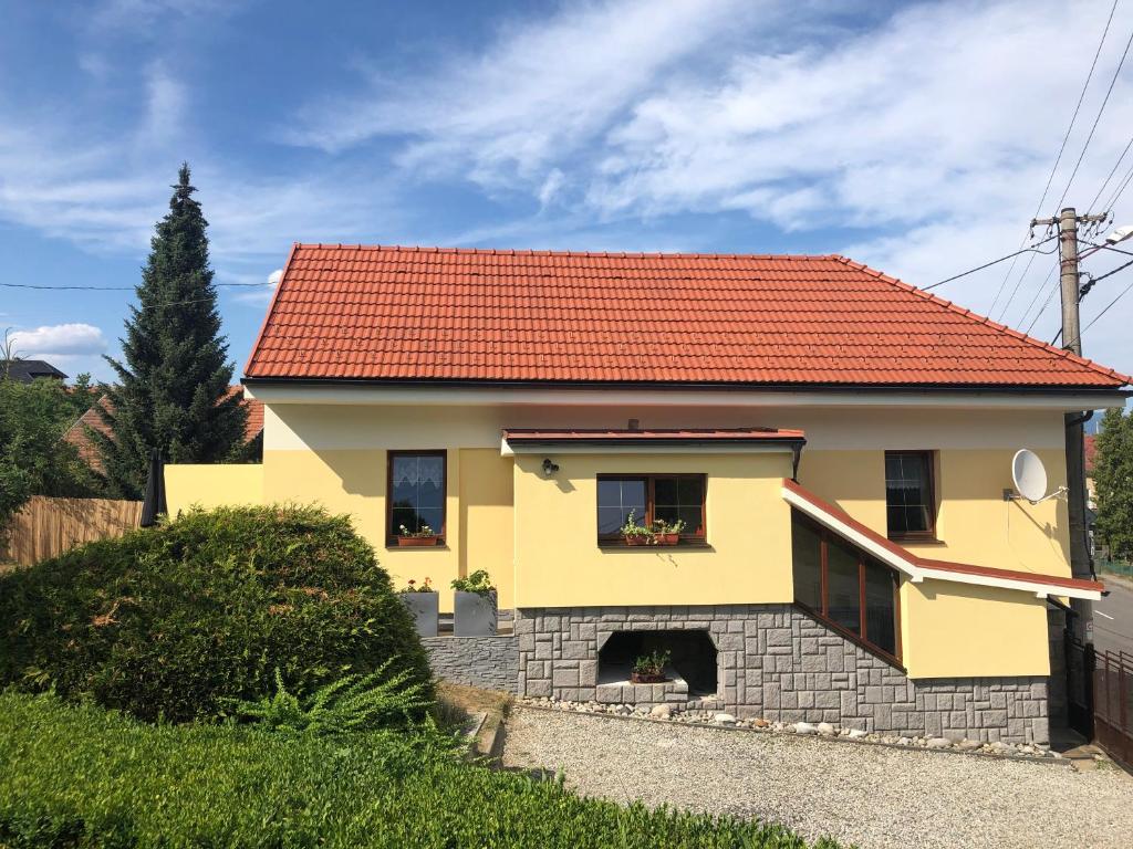una casa amarilla con techo rojo en Domcek pri Medokysi, en Liptovský Mikuláš