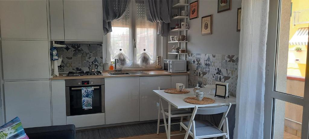 una piccola cucina con tavolo e bancone di La Guendy al mare a Civitanova Marche