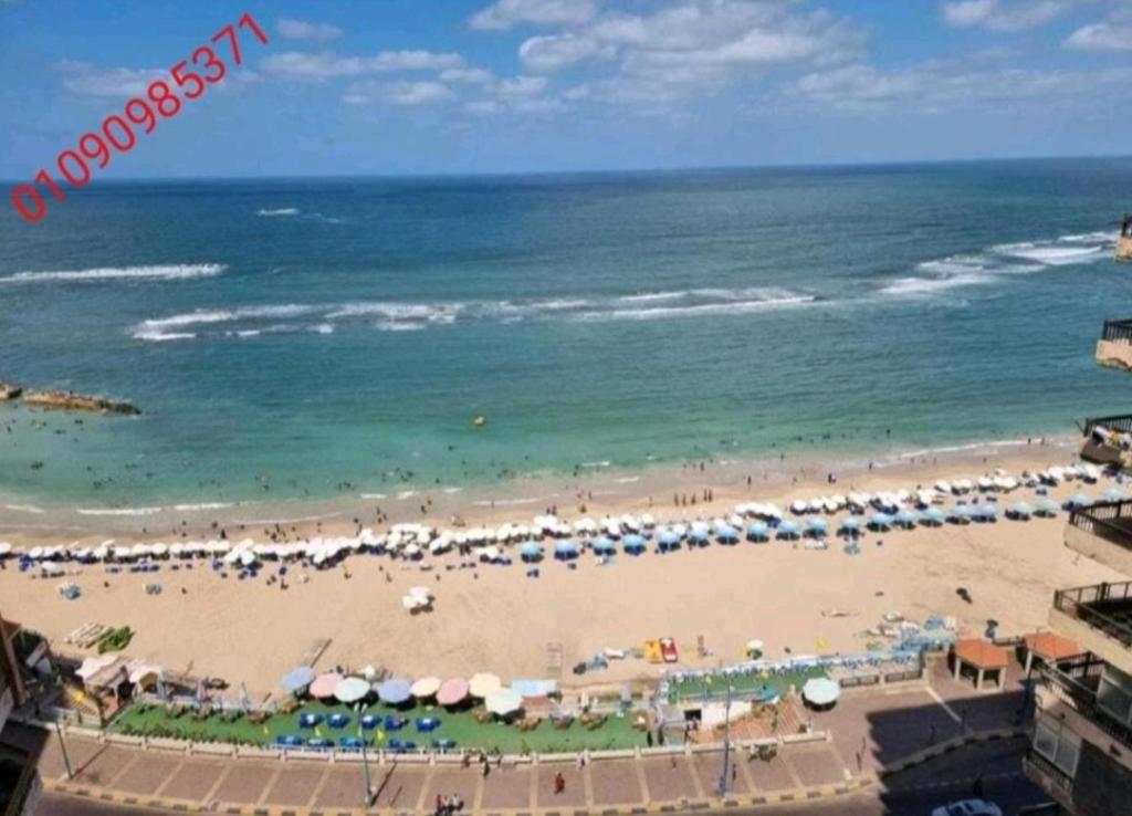 a view of a beach with umbrellas and the ocean at Panoramic Sea View Flat miami FAMILY ONLY شقة بانورما بشاطئ ميامي الاسكندرية عائلات فقط in Alexandria