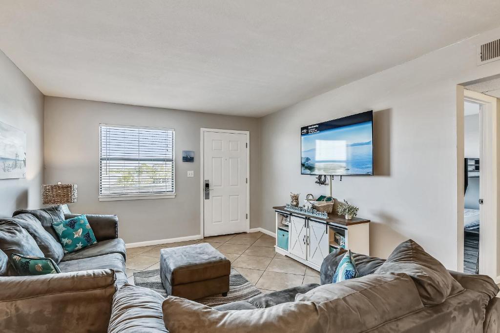 uma sala de estar com um sofá e uma televisão de ecrã plano em Venus 306 condo em Fort Walton Beach
