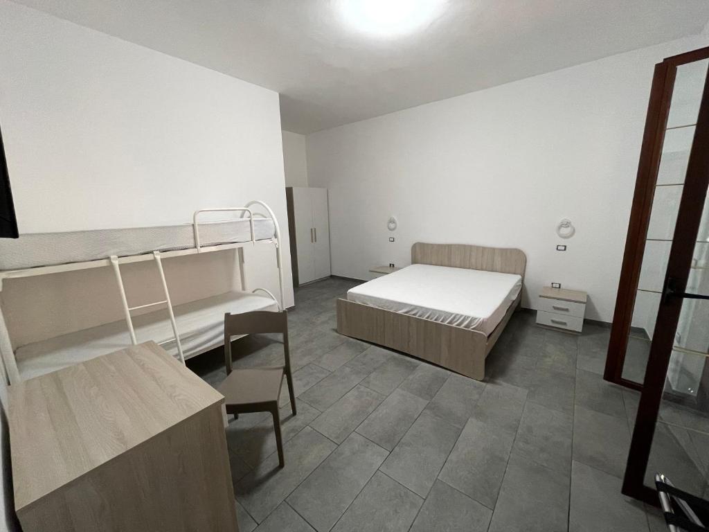 pokój z dwoma łóżkami piętrowymi i stołem w obiekcie Il Vicolo w mieście Marina di Schiavonea