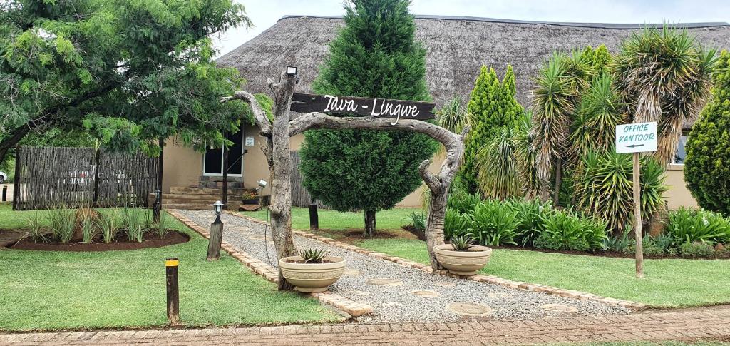 Tava Lingwe Game Lodge & Wedding Venue في بارايس: علامة أمام منزل به نباتات