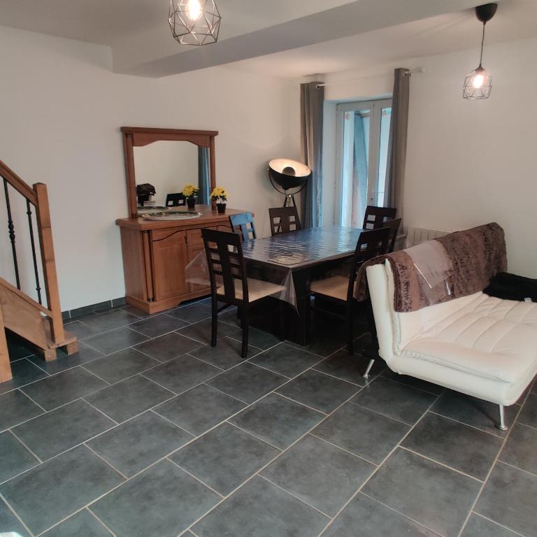 una sala da pranzo con tavolo e sedie di Maison avec Jardin avec 3 chambres a Corquilleroy