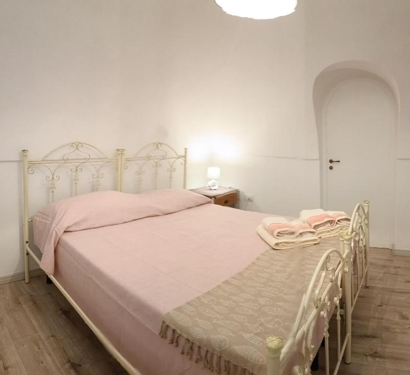 a bedroom with a white bed with pink sheets at CasaCalò in Gallipoli