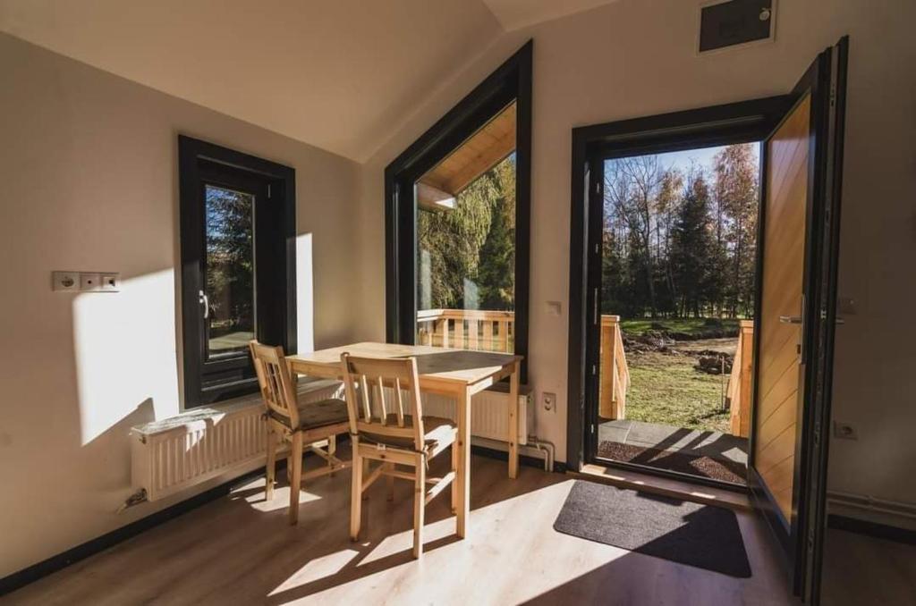 a dining room with a table and chairs and windows at Birtok Houses - twin no. 2 for 2 people in Borzont