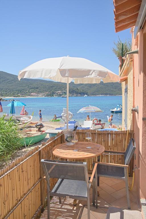 stół, krzesła, parasol i plaża w obiekcie Oyster Beach - Direttamente sulla Spiaggia del Forno w mieście Scaglieri