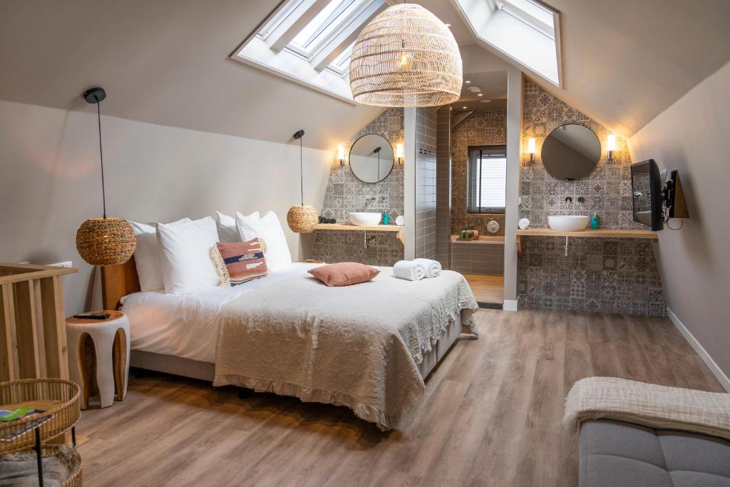 een slaapkamer met een groot bed en een badkamer bij Just Texel Suites & Apartments in Den Burg