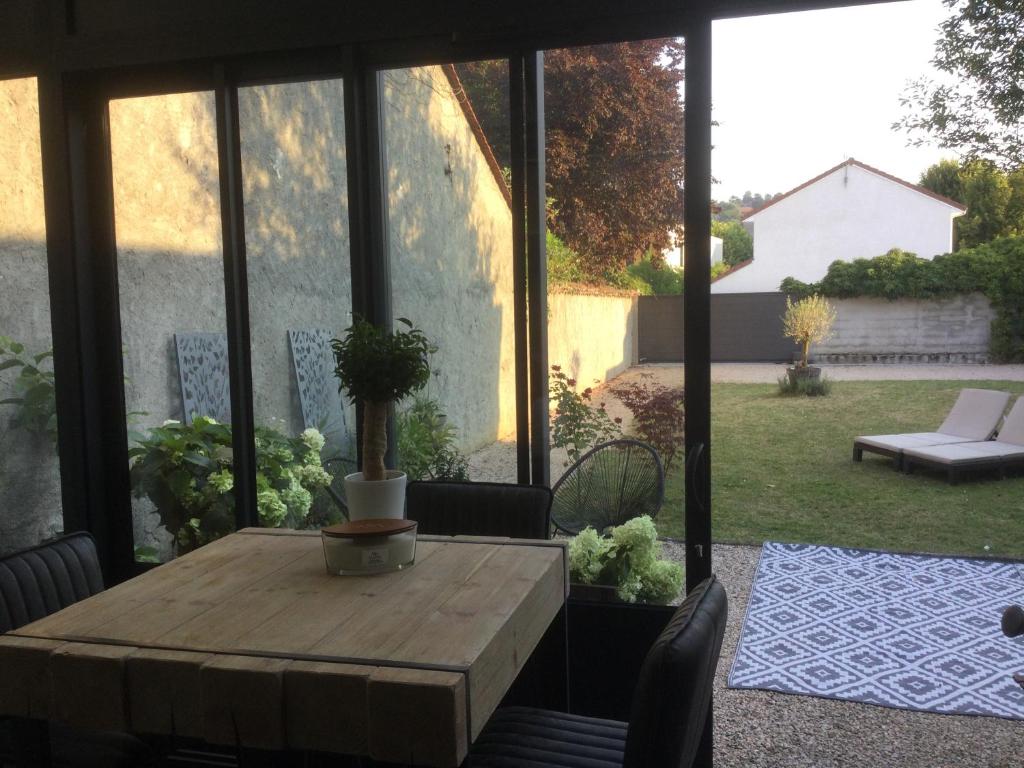 a screened in porch with a wooden table and chairs at Le Clos de la tour in La Tour-du-Pin