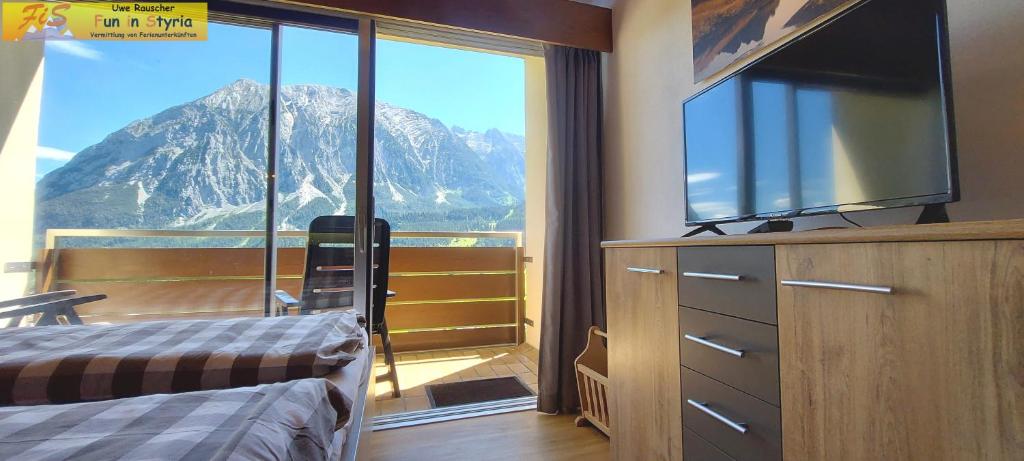 Schlafzimmer mit einem großen Fenster mit Bergblick in der Unterkunft Apartment Salzkammergut by FiS - Fun in Styria in Tauplitz