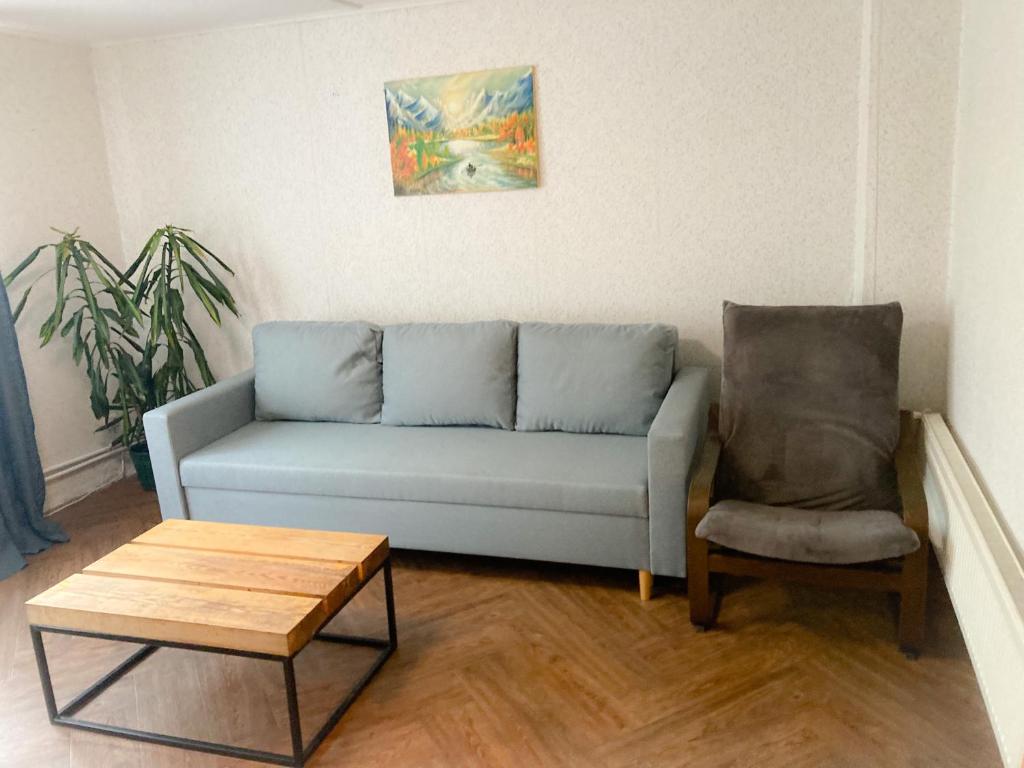 een woonkamer met een blauwe bank en een stoel bij Apartaments Ogre. in Ogre
