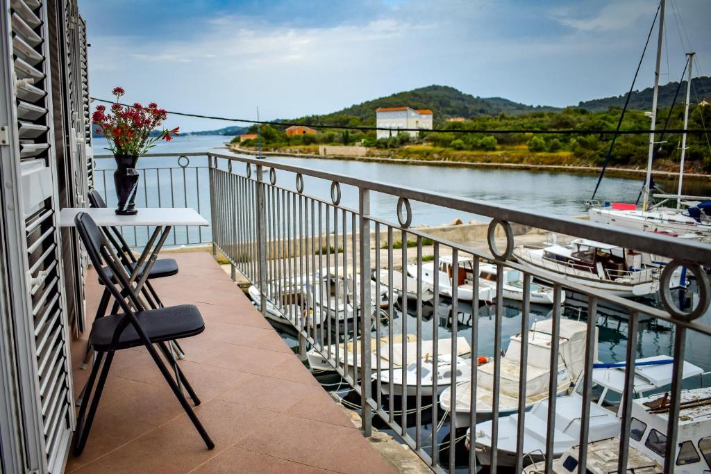d'un balcon avec des chaises et une vue sur la rivière. dans l'établissement Maslinčica, à Veli Iž