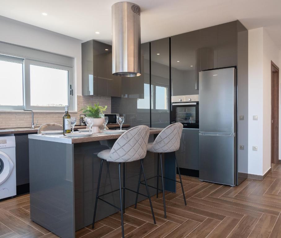 a kitchen with a island with two bar stools at Apartment Santa Marina 4 in Asgourou