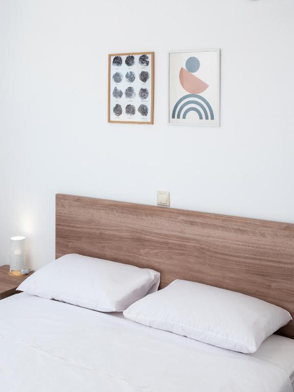 two beds in a bedroom with a wooden headboard at Apartment Santa Marina 4 in Asgourou