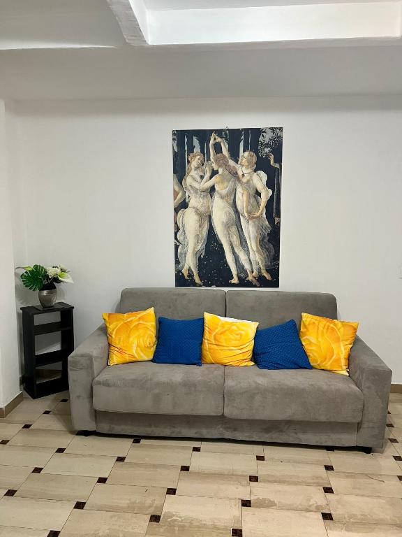 a living room with a gray couch with yellow pillows at Celeste Apartment in Genoa