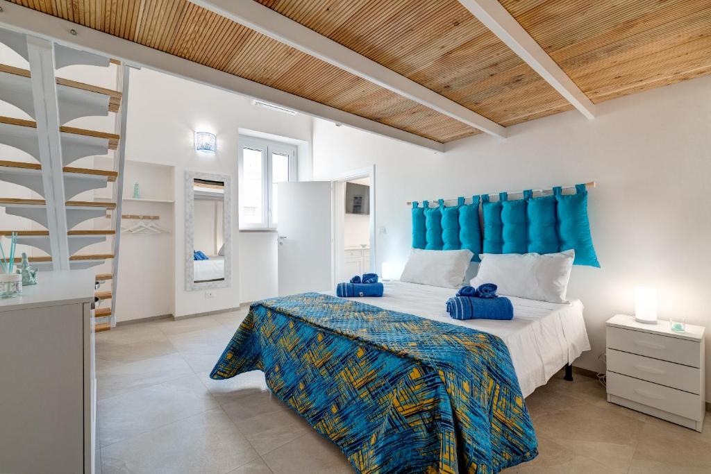 een slaapkamer met een groot bed met een blauw hoofdeinde bij Angolo del Sole in Villanova di Ostuni