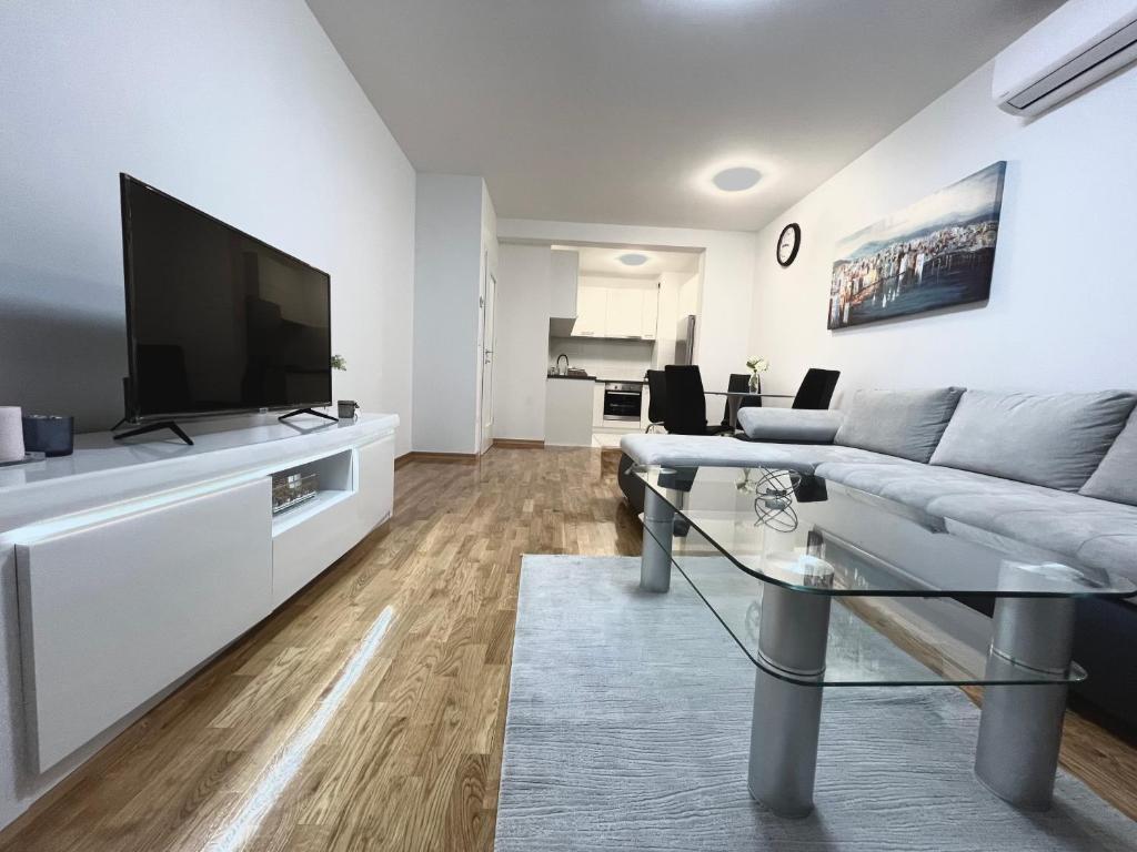 Apartman Anton في زغرب: غرفة معيشة مع أريكة وتلفزيون بشاشة مسطحة