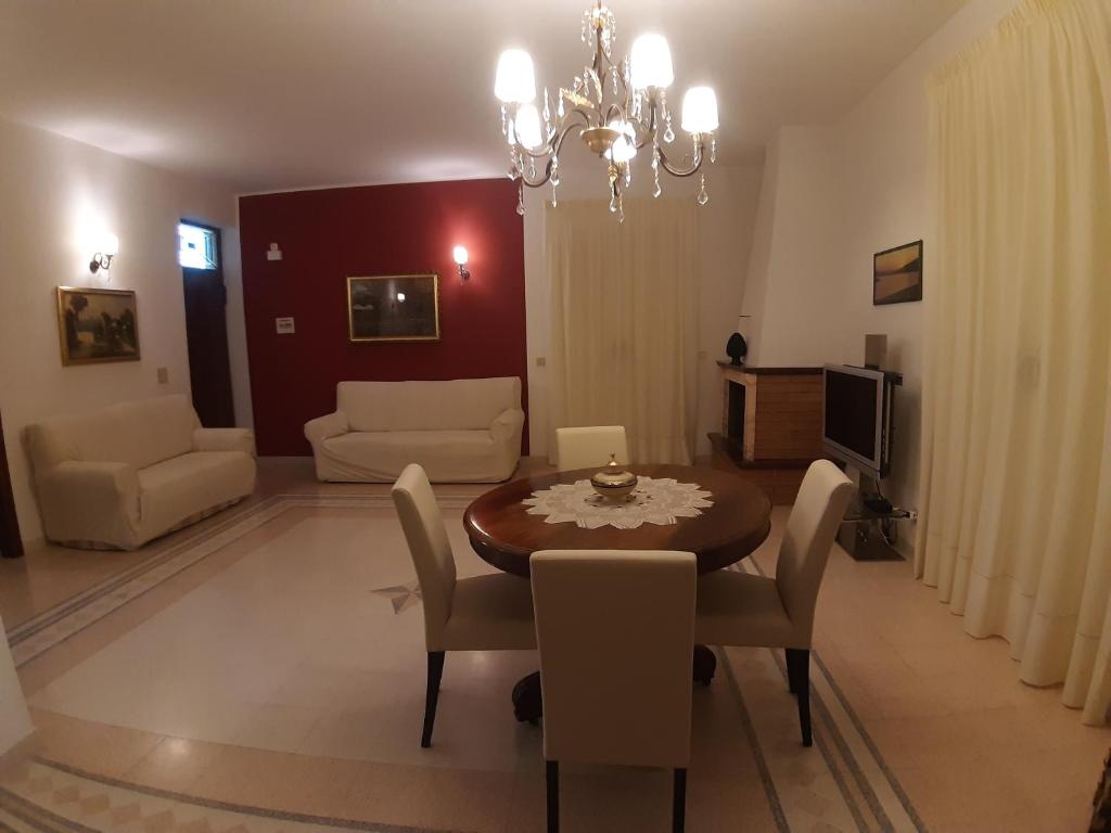 a living room with a dining room table and chairs at Villa Guido in Regalbuto