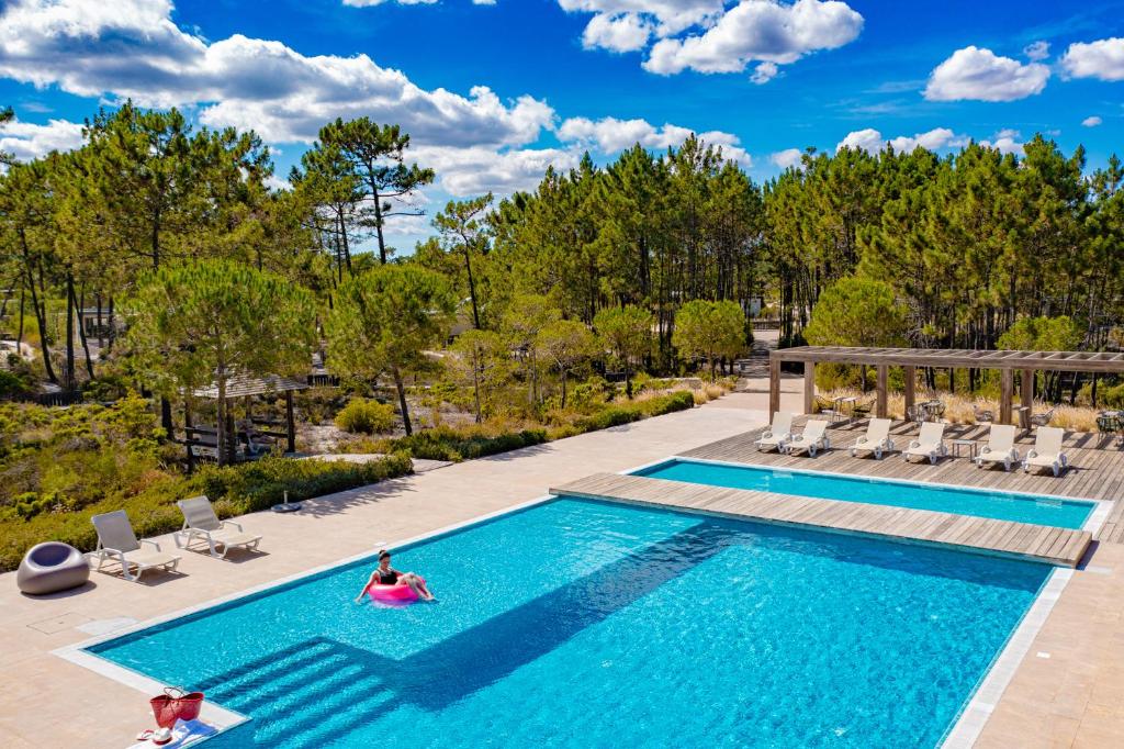 ein Schwimmbad mit zwei Personen in einem Schwimmpoolvisor in der Unterkunft Pestana Troia Eco-Resort & Residences in Troia