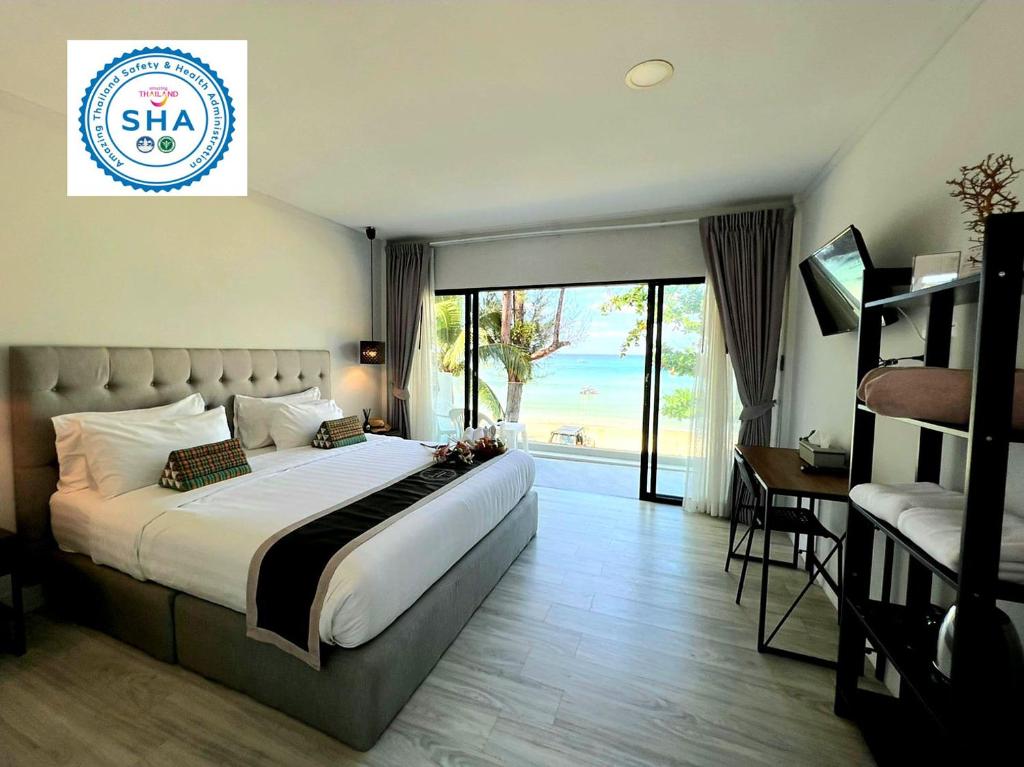 卡馬拉海灘的住宿－泰國卡馬拉海濱酒店，酒店客房设有一张大床和一个阳台。
