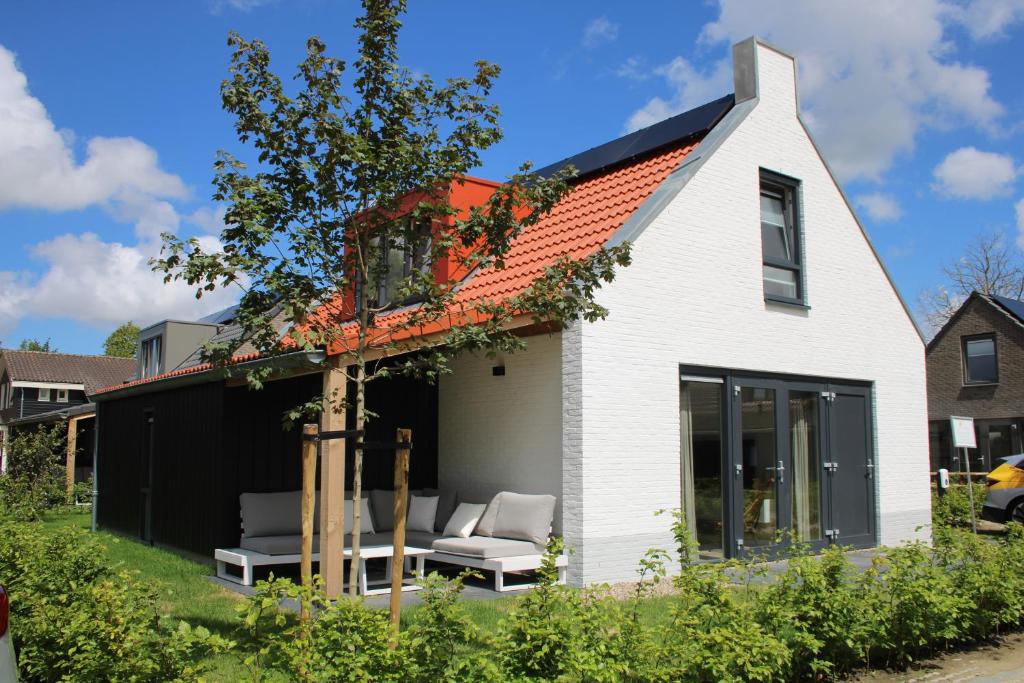 a white house with a couch and a window at Dromen in de duinen by Droomvilla in Sint Maarten