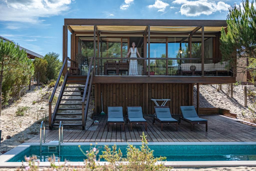 a house with a deck next to a pool at Pestana Troia Eco-Resort & Residences in Troia