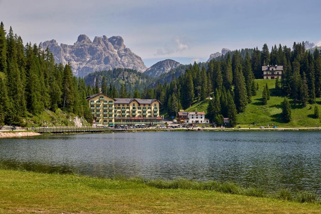 un hôtel sur un lac avec des montagnes en arrière-plan dans l'établissement Grand Hotel Misurina, à Misurina