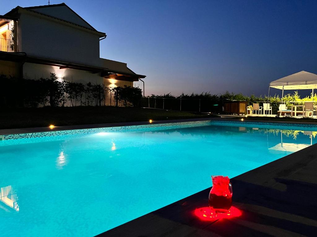una grande piscina di notte di Country House Andromeda a Offida