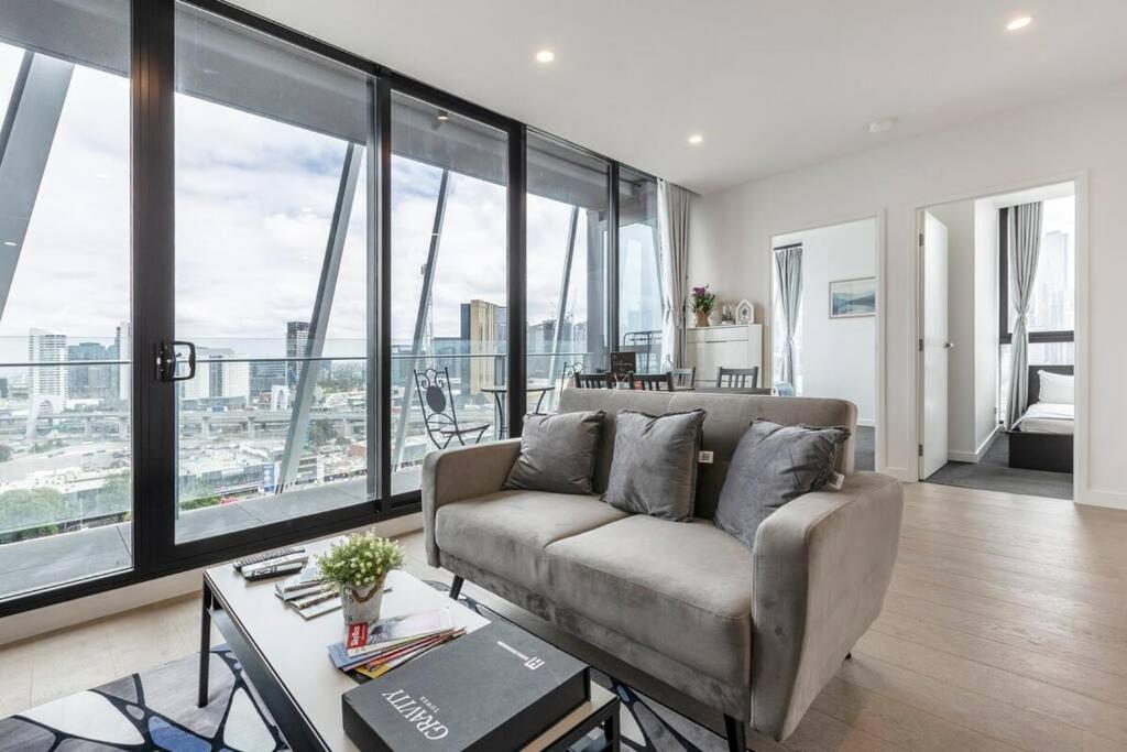 a living room with a couch and large windows at Modern 2 Beds Apartment with Amazing City View in Melbourne