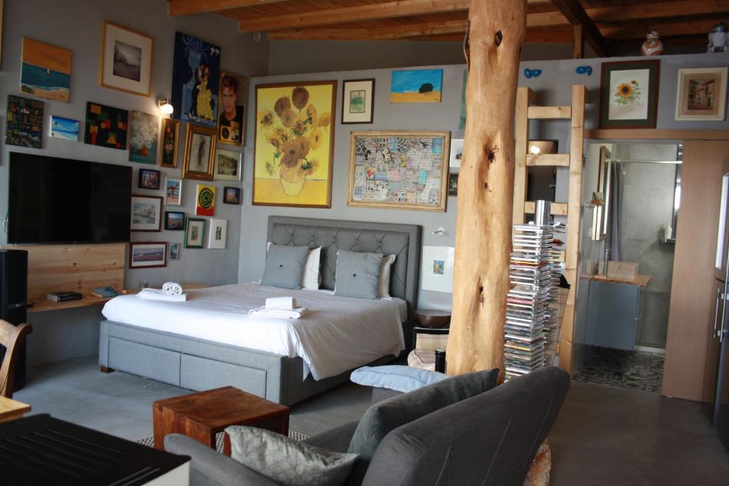 a bedroom with a bed and a living room with a ladder at Estúdio com espaço exterior, 5 minutos de Cascais. in Cascais