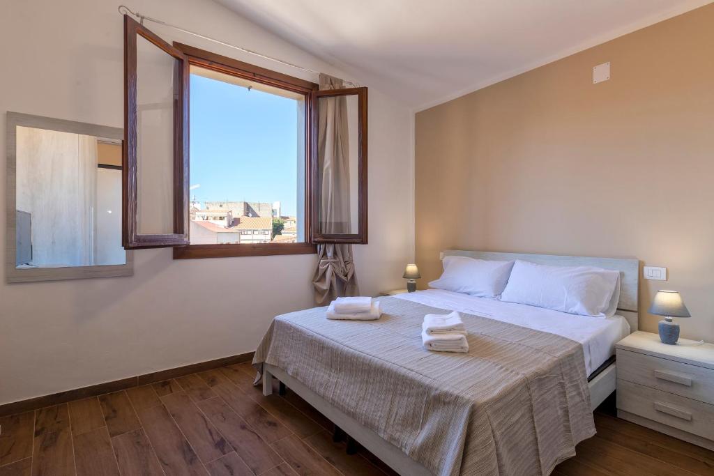 a bedroom with a bed with two towels on it at Vico Rooms in Sassari