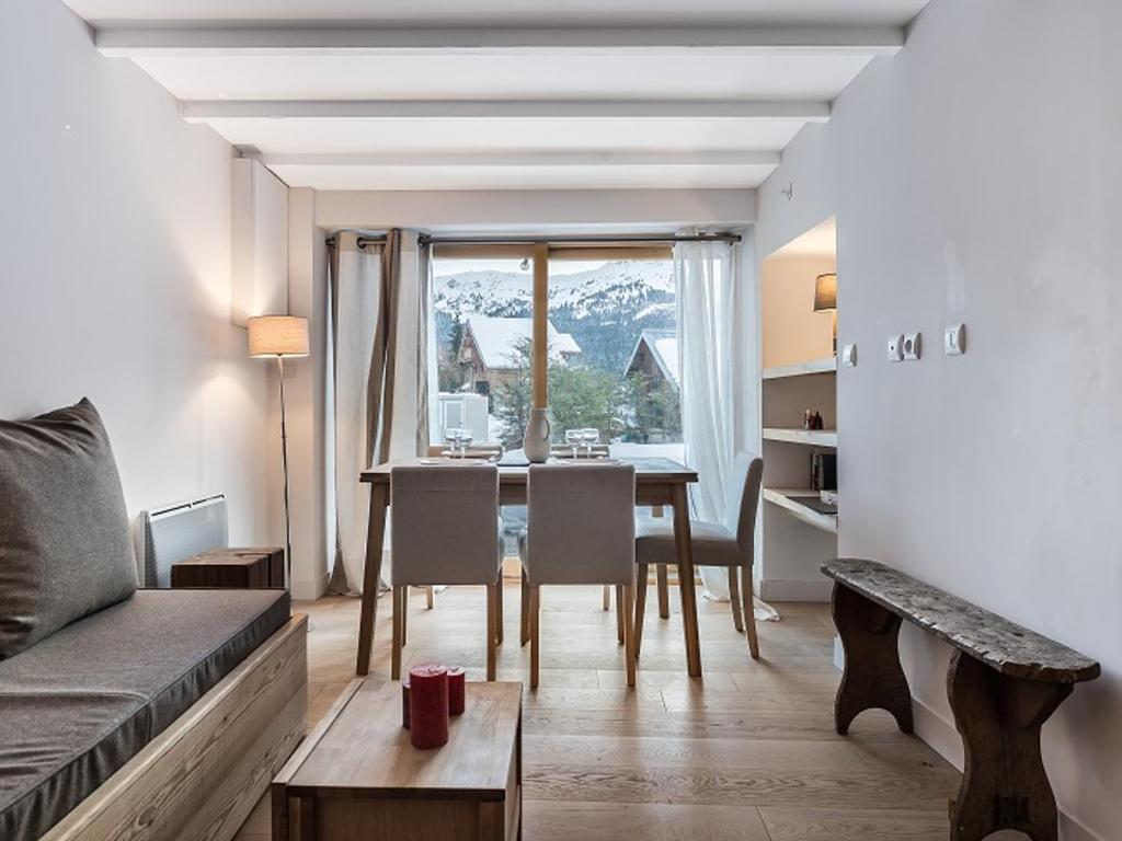 ein Wohnzimmer mit einem Sofa und einem Tisch mit Stühlen in der Unterkunft Maison Méribel, 3 pièces, 6 personnes - FR-1-566-21 in Les Allues