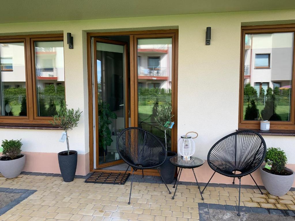 two chairs and a table in front of a building at APARTAMENT OFELIA in Darłowo