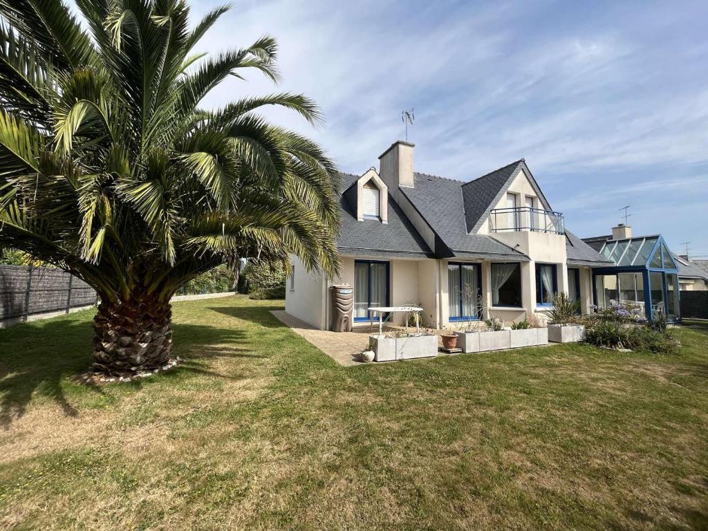 a palm tree in front of a house at Maison Fouesnant, 5 pièces, 8 personnes - FR-1-481-103 in Fouesnant