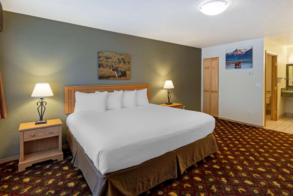 a large bed in a hotel room with two lamps at Best Western King Salmon Inn in Soldotna