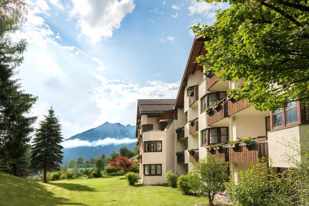 um edifício de apartamentos com vista para uma montanha em Dorint Sporthotel Garmisch-Partenkirchen em Garmisch-Partenkirchen