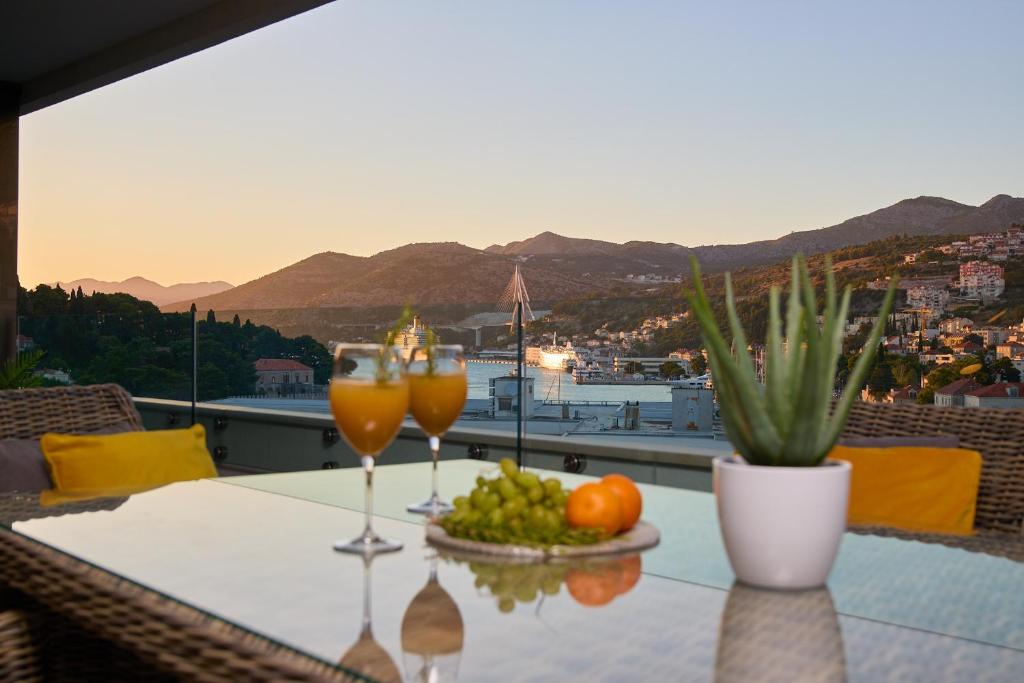 una mesa con dos copas de vino y un tazón de fruta en Hedera Estate, Hedera A15, en Dubrovnik