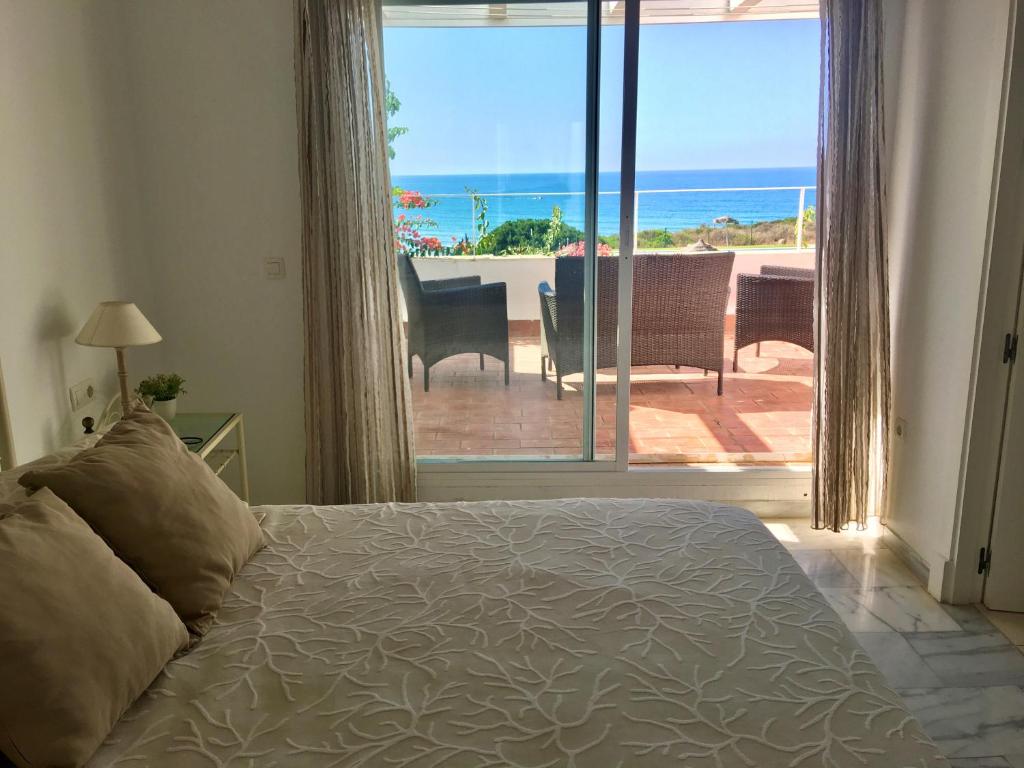 1 dormitorio con cama y vistas al océano en Villa Mar Fuente del Sol, en Conil de la Frontera