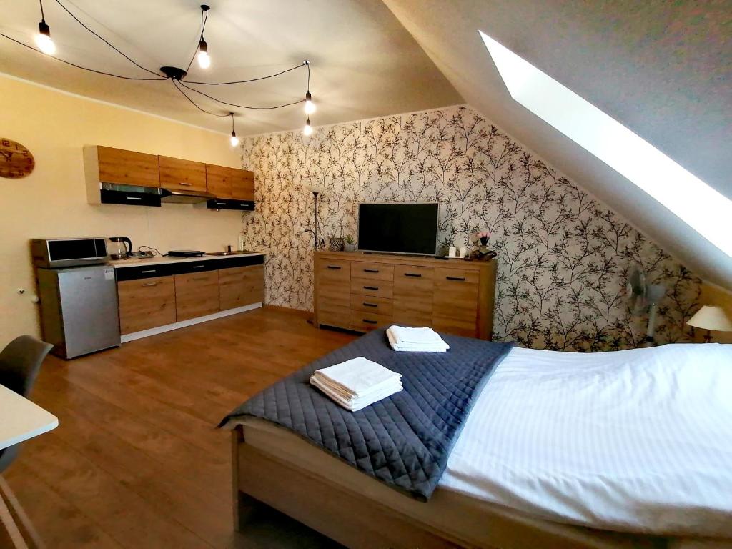 a bedroom with a white bed and a kitchen at Apartament z pięknymi widokami, około 900m do przejrzystego jeziora Choczewskiego, blisko morza in Perlino
