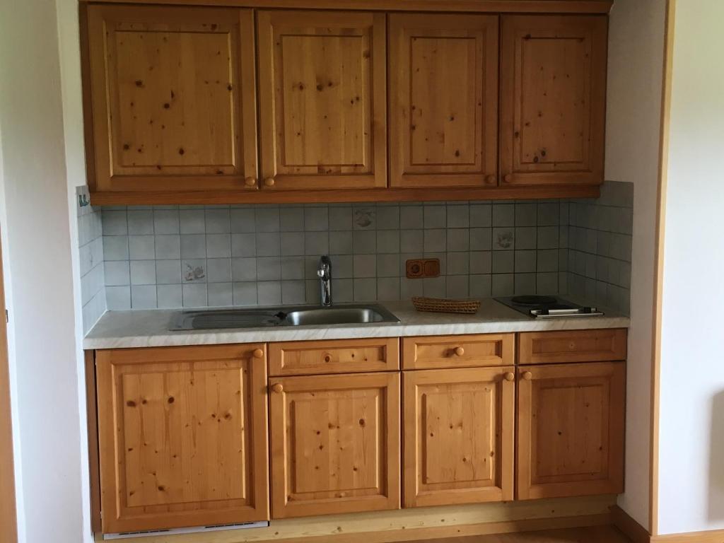 a kitchen with wooden cabinets and a sink at Appartement Oberlacken in Sankt Johann in Tirol